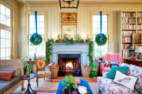 Living Room decorated for Christmas with wreaths in the windows and garland on the mantel