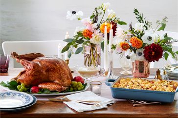 a Thanksgiving table setting with turkey and casserole