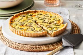 Southern Living Fiddlehead-and-Bacon Tart sliced on a platter to serve