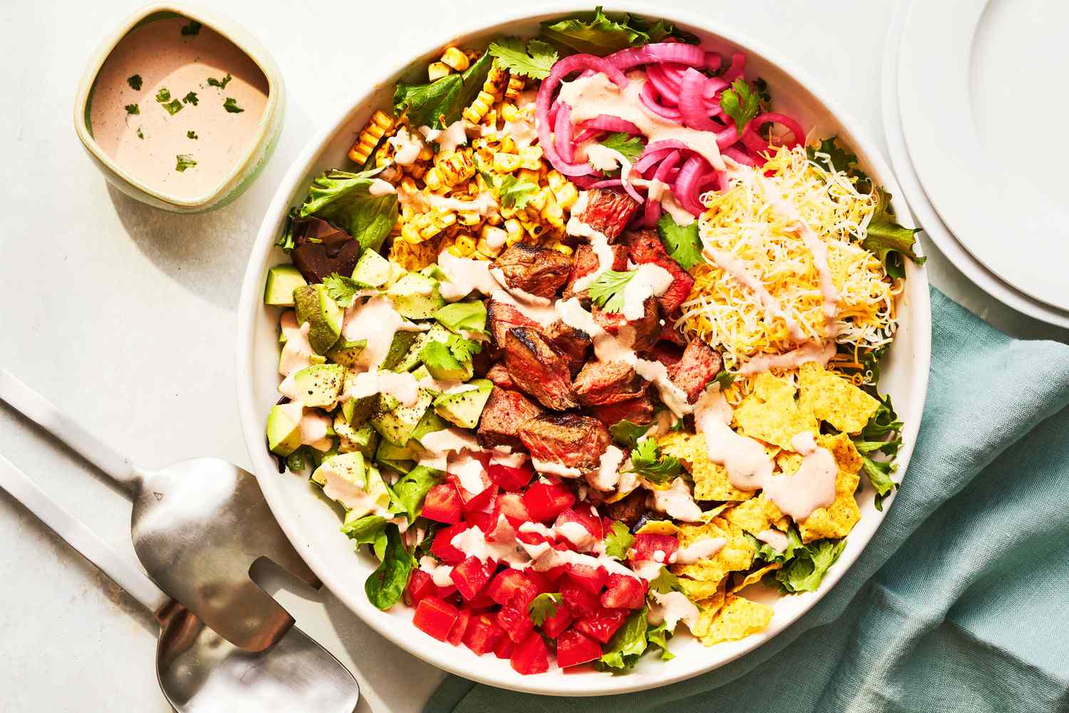 Southern Living Steak Taco Salad in a bowl to serve with extra dressing beside