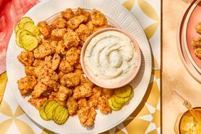 homemade chicken nuggets on a white plate with pickles and a side of ranch dressing - Southern Living