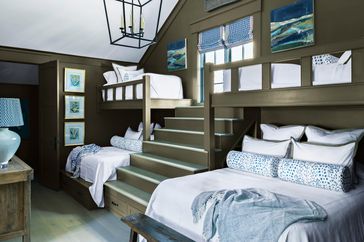 Dark green bunk room with two queen beds and single upper bunks