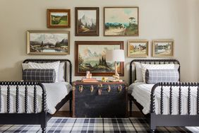 Twin Jenny Lind Beds with Plaid Rug, Trunk, and Gallery Wall