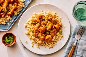 Southern Living Bourbon Chicken on a plate to serve with the platter beside