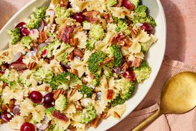 Broccoli, Grape, and Pasta Salad in a white bowl with golden spoon