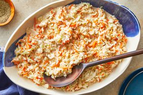 coleslaw in a bowl with a wooden spoon