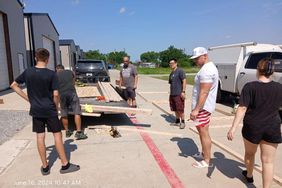 Several Dads Working Outside On Wooden Sets