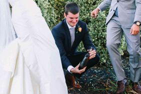 Bride and groom digging up bottle of bourbon