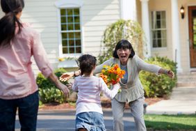 child running to grandmother with flowers