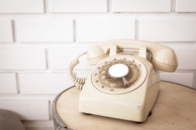 white rotary phone on table