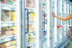 Woman's Arm Opening Freezer Door at Grocery Store