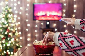 Christmas eve. Alone woman eating popcorn, watching tv