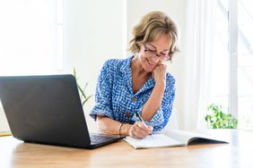 Woman Wearing Blue Dress Writing In Notebook