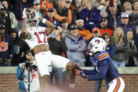 Isaiah Bond #17 of the Alabama Crimson Tide catches a pass for a touchdown in front of cornerback D.J. James #4 of the Auburn Tigers during the second half of play at Jordan-Hare Stadium on November 25, 2023 in Auburn, Alabama