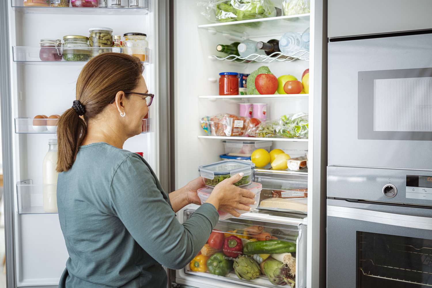 woman putting containers in fridge