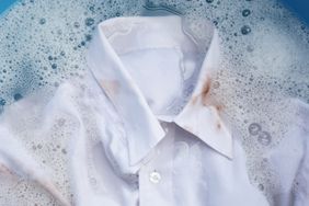 Dirty choclate stain on white shirt soaking in water with soapy detergent