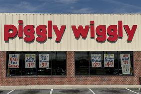 The exterior of a Piggly Wiggly grocery store with signs in the windows