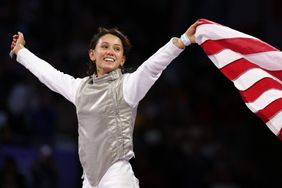 US' Lee Kiefer celebrates with her country's flag after winning against US' Lauren Scruggs in the women's foil individual gold medal bout during the Paris 2024 Olympic Games at the Grand Palais in Paris