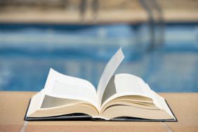 The book in front of swimming pool in the summer day