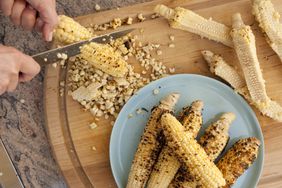 cutting grilled corn off cob with knife