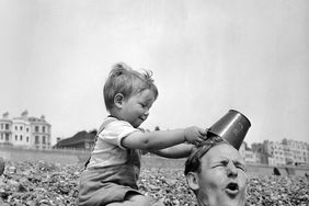 Baby Burying Dad in Sand at the Beach