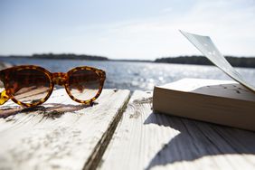 Sunglasses and book on pier