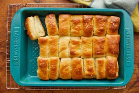 Bakes parker house rolls in a baking dish on a wire rack