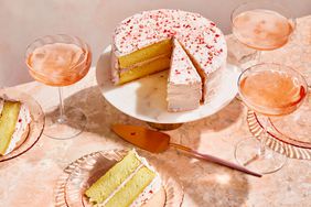 Pink Champagne Cake on a cake stand with glasses of pink champagne