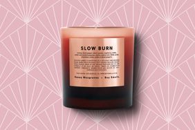 One of the best gifts for homebodies, the Slow Burn candle, on a pink deco patterned background. 