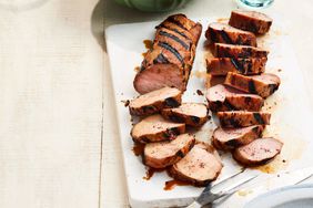 Southern Living Sweet-and-Smoky Grilled Pork Tenderloins sliced on a cutting board 