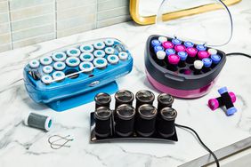 Three different hot rollers on a marble bathroom counter.