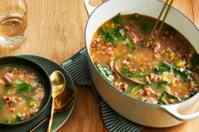 Black-eyed pea soup with ham hocks in white pot with smaller bowl of soup