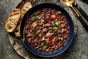 Ham hock-and-black bean soup in blue bowl with bread