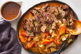 Southern Living Instant Pot Pot Roast on serving platter with pitcher of sauce beside