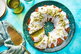 Southern Living Pistachio Cake on serving platter with a few slices cut and a cake server beside the plate