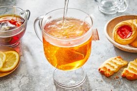 pouring hot water into a tea cup with a tea bag