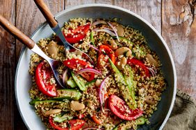 Millet Salad with Butter Beans, Okra, and Garlicky Marinated Tomatoes in a serving bowl with serving spoons.