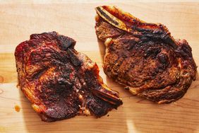 cooked ribeye steaks on a cutting board - Southern Living