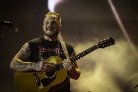 Zach Bryan Holding Guitar at Mic