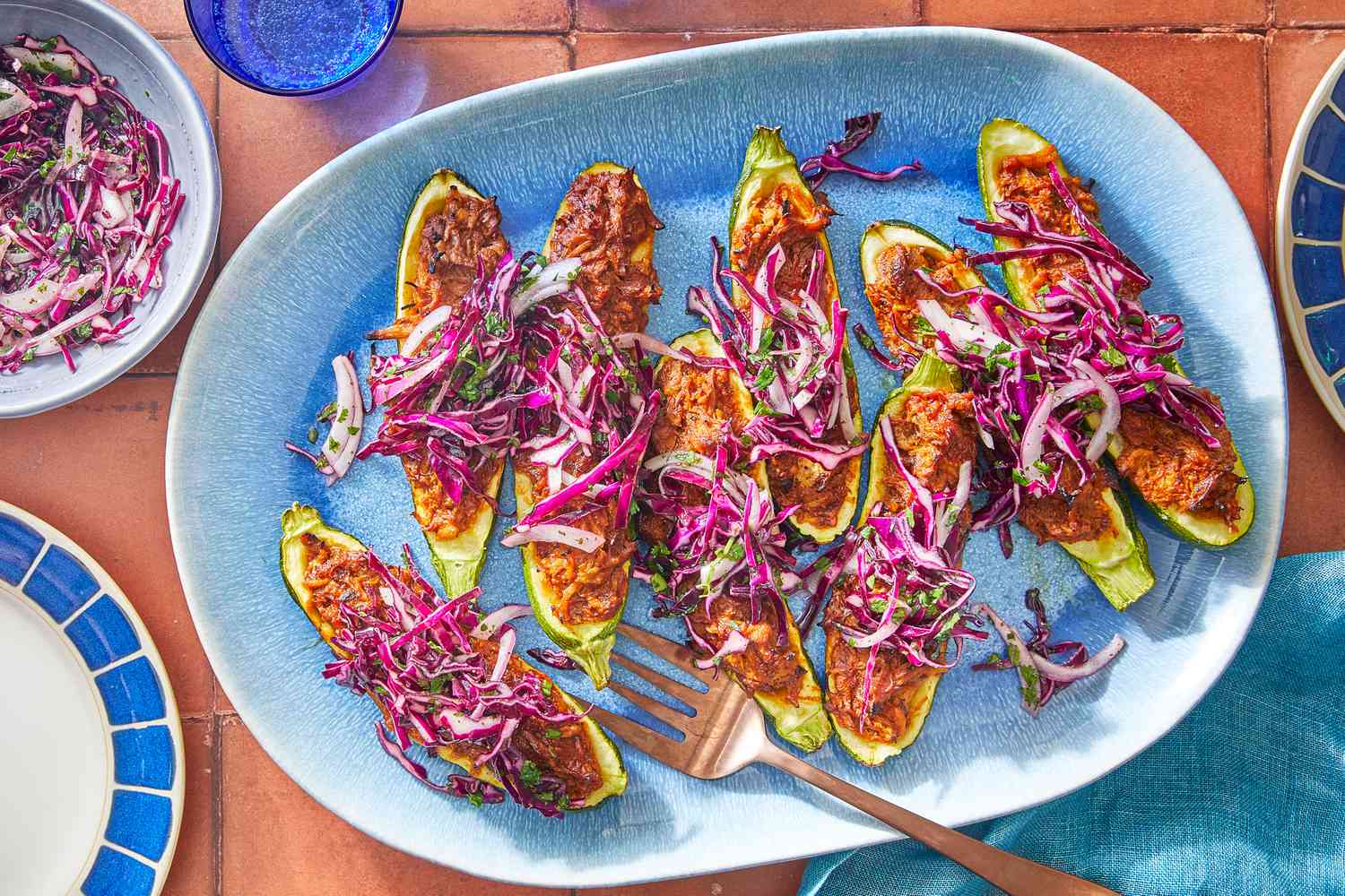 Southern Living Zucchini Boats on a platter to serve, topped with slaw